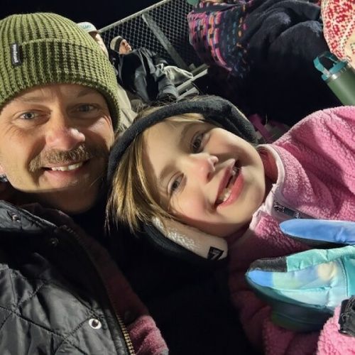 Josh Motes of Nelson Exteriors taking a close-up selfie with a child at an outdoor event