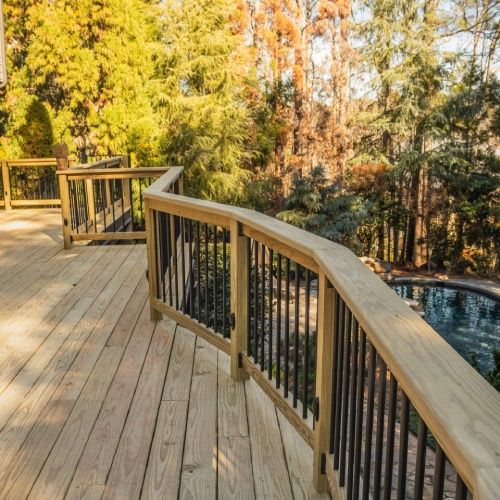 Freshly built wooden deck with black railing by Nelson Exteriors