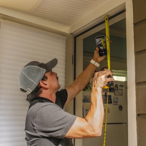 Chris Hall measuring a doorway for exterior renovation by Nelson Exteriors