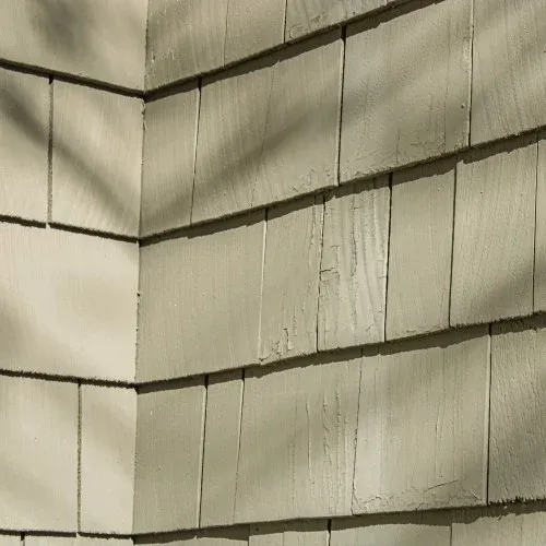 Close view of cracked, aged wood siding on home exterior by Nelson Exteriors in Atlanta, GA