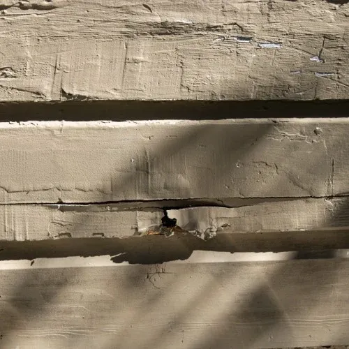 Example of cracked siding on home exterior showing signs of damage by Nelson Exteriors in Atlanta, GA