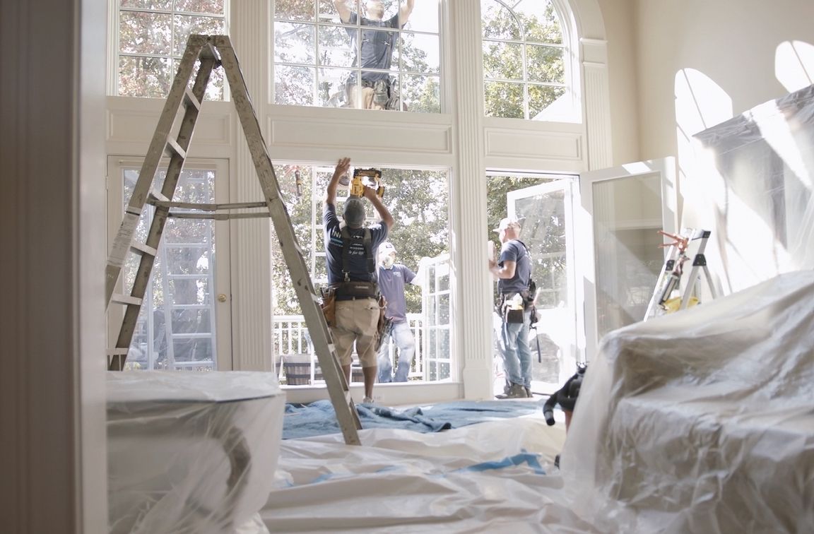 Workers from North Georgia Replacement Windows installing Infinity from Marvin Windows in a two-story entryway.