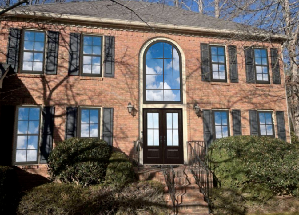 Red brick home with a rendering of what new windows and a new double door could look like on the home.