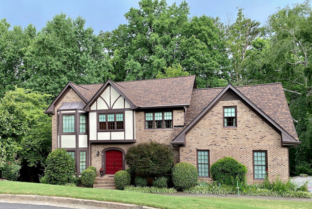 Brown fiberglass window frames on a brick home