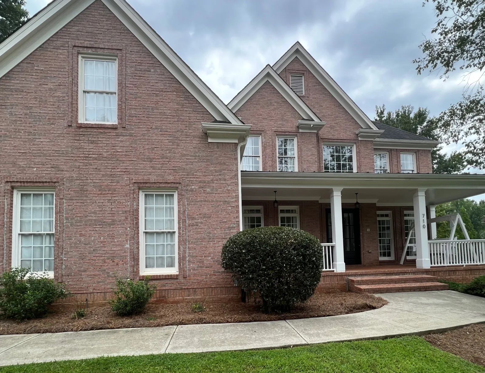 Red brick home with old white windows. 