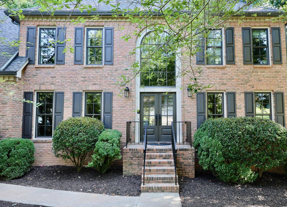 Brick home with Infinity from Marvin bronze fiberglass windows and a new double entry door.