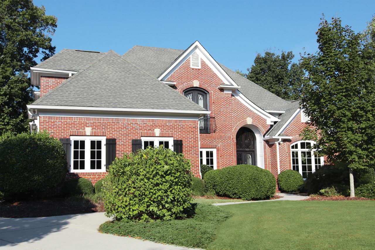 White fiberglass window frames on a brick home