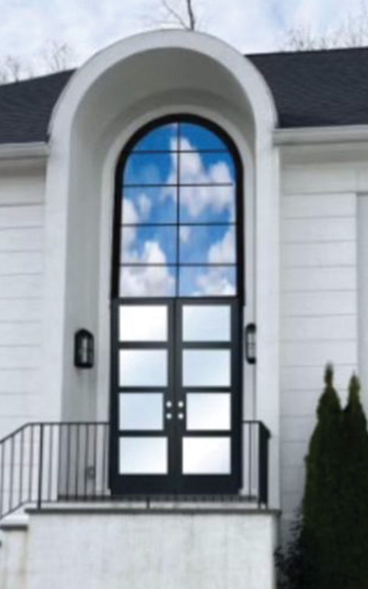 Rendering of an iron door and foyer window on a white home.