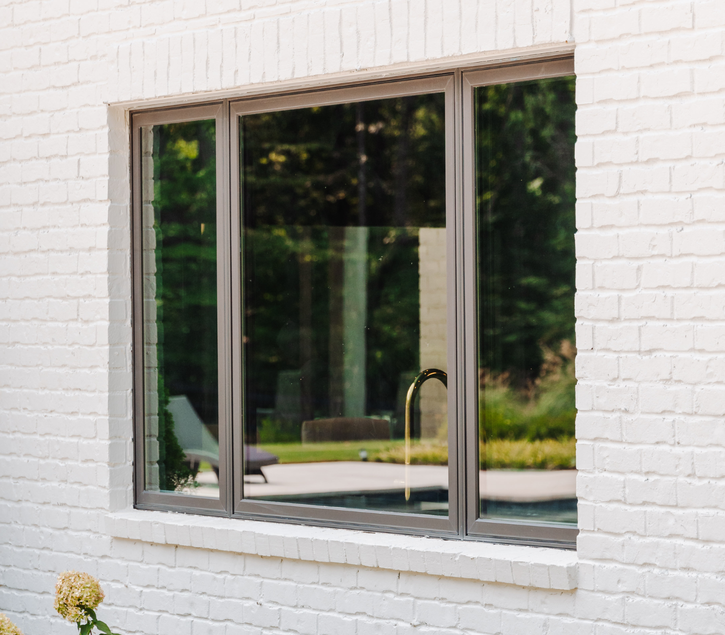Bronze casement windows installed in white brick house's kitchen