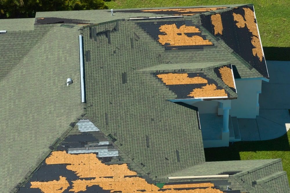 wind damaged shingles and missing shingles on a residential roof