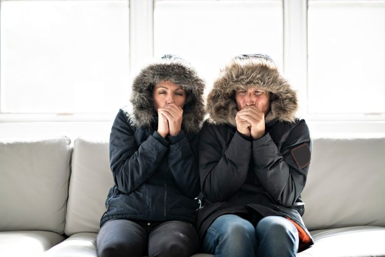 Couple shivering from the cold inside their home