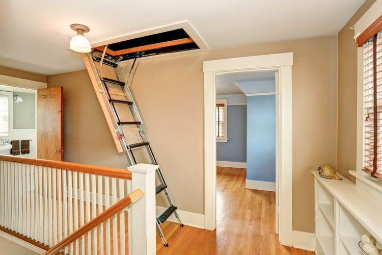 Open attic hatch with stairs in hallway