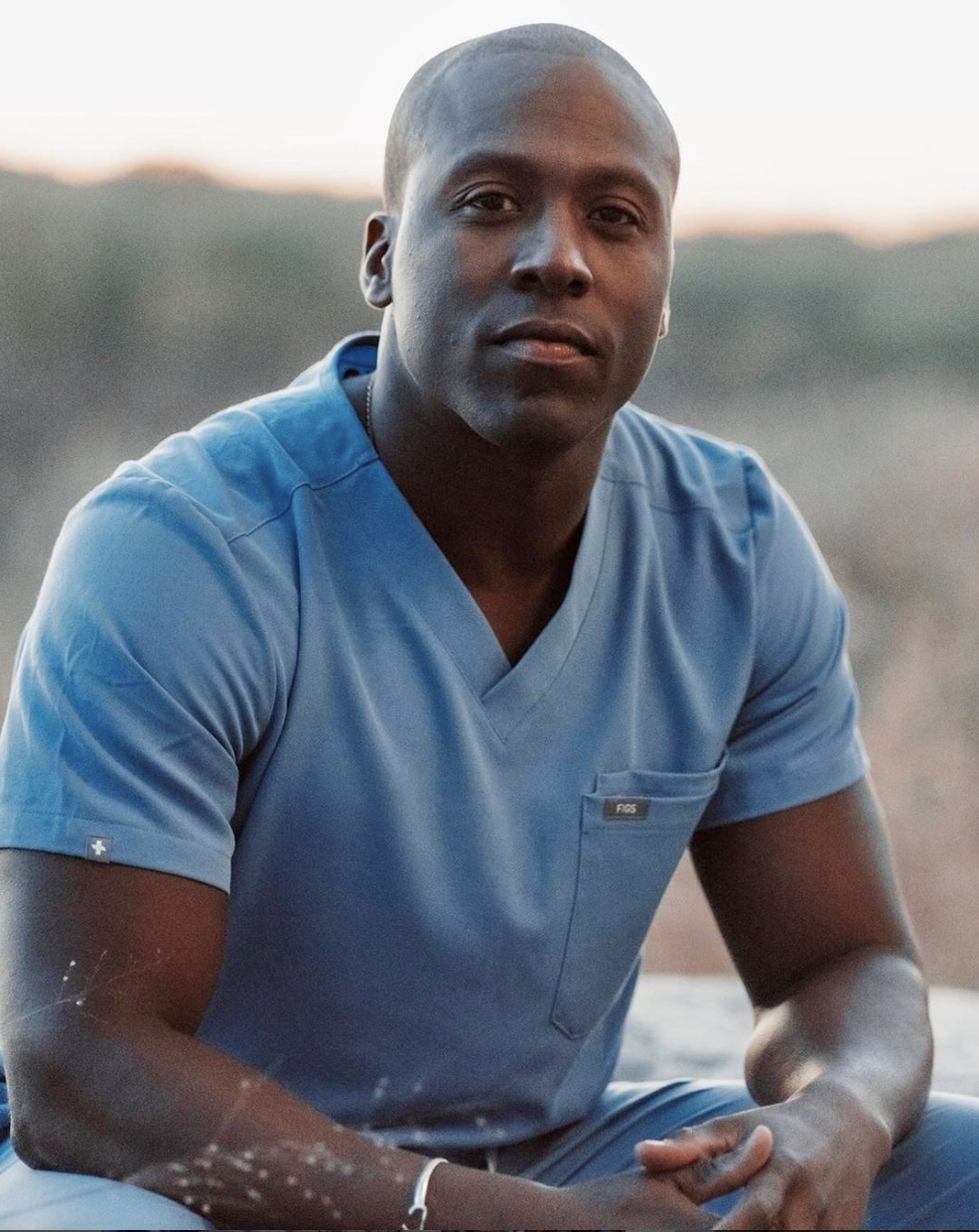 Dr. Elvis Francois poses in a field.