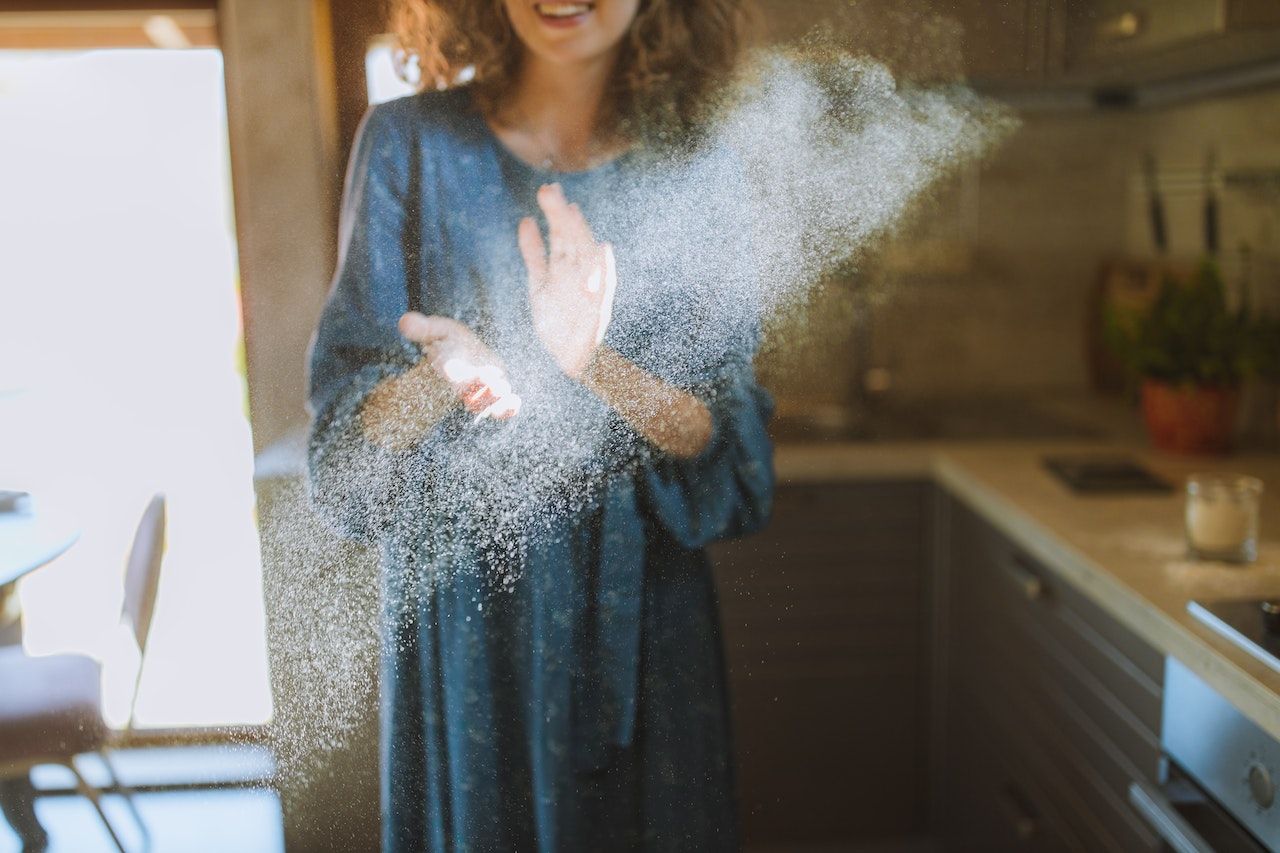 woman clapping dust in the air in the sunlight