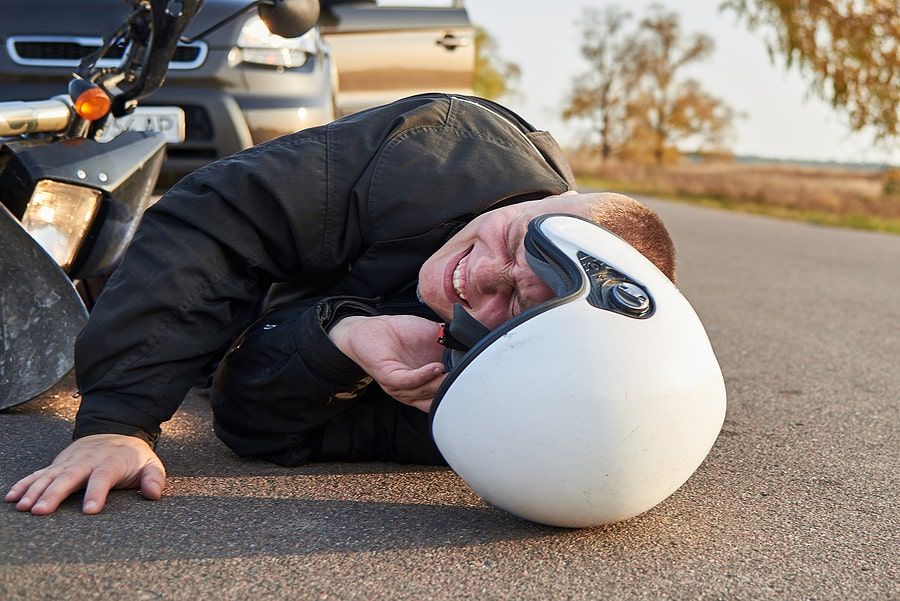 A man lying on the ground after a motorcycle accident 