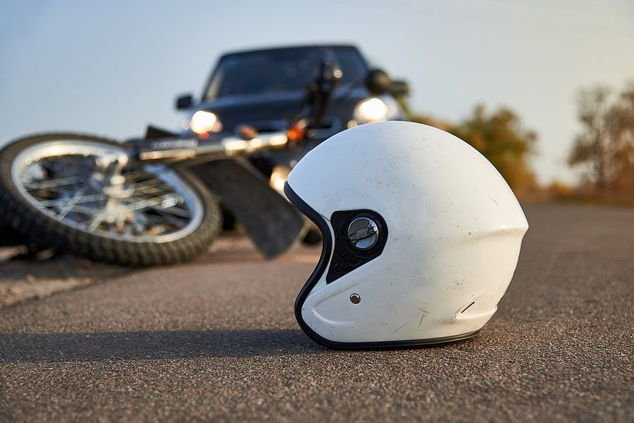 A crashed motorcycle and helmet in the road