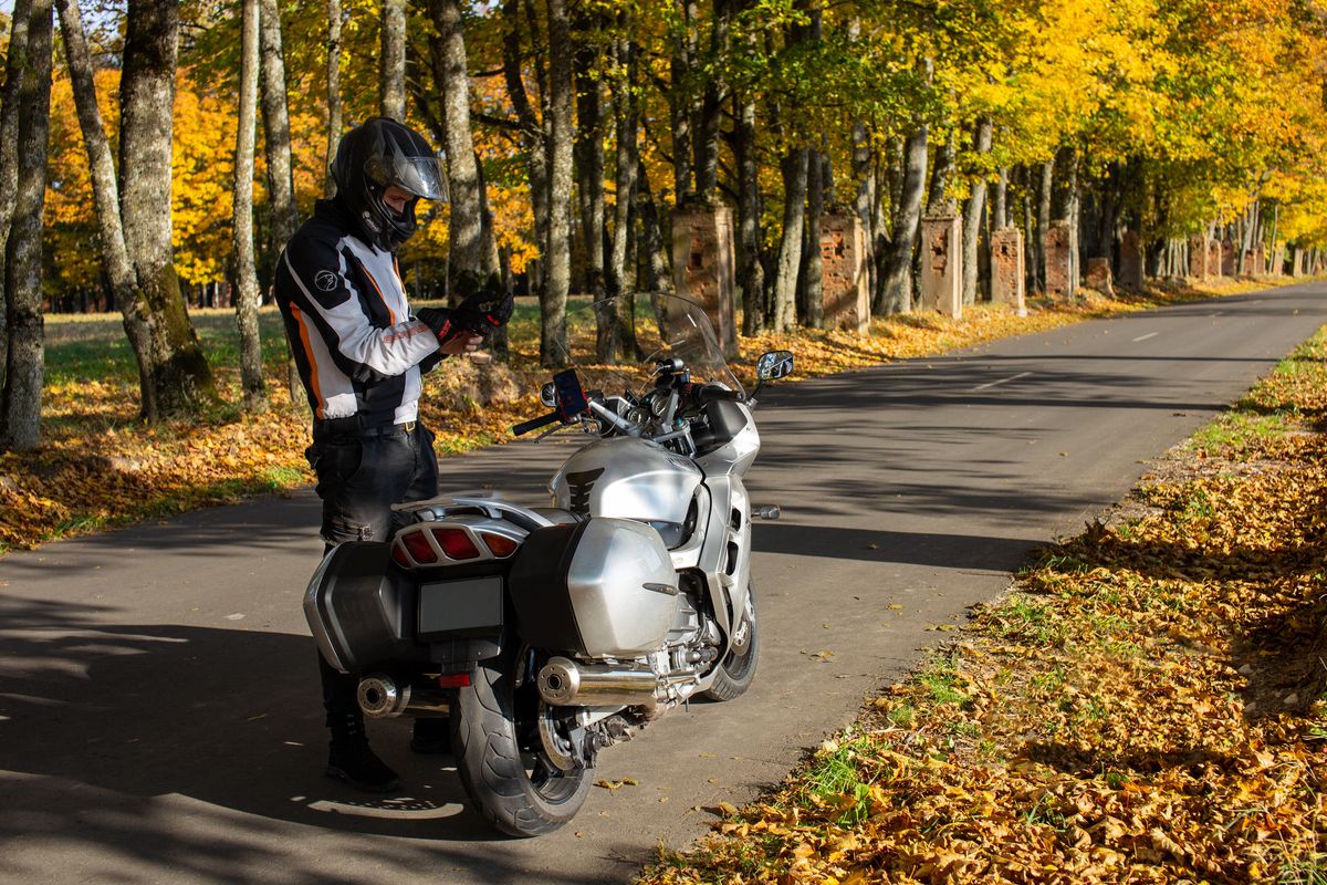 man standing next to a bike in the autumn