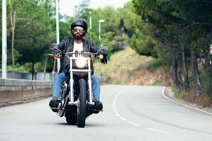 A motorcycle rider driving down the middle of the road