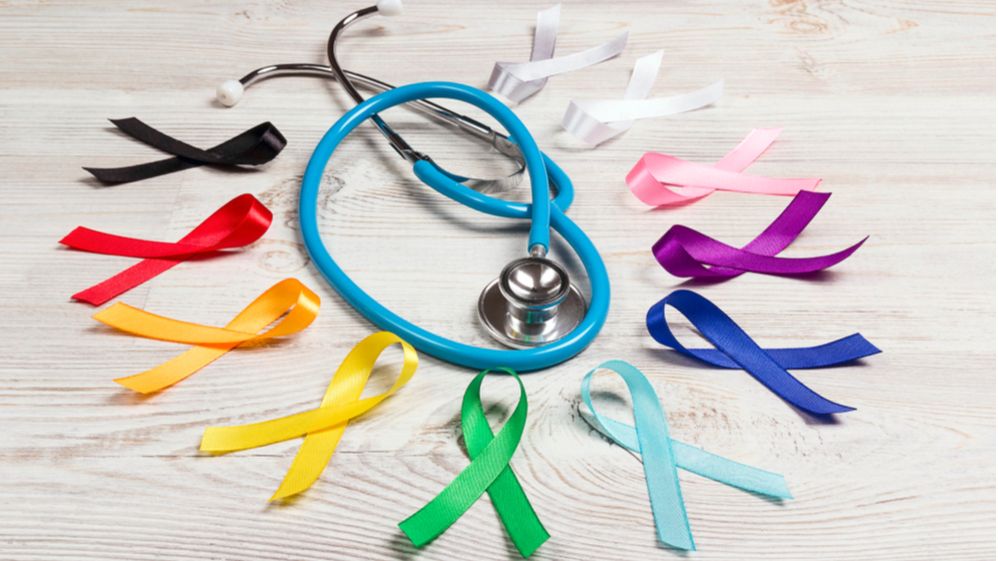 A circle cancer ribbons in many different colors surrounding a blue stethoscope
