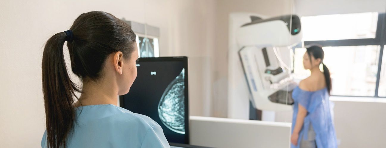 Doctor administering a mammogram on a patient to screen for breast cancer