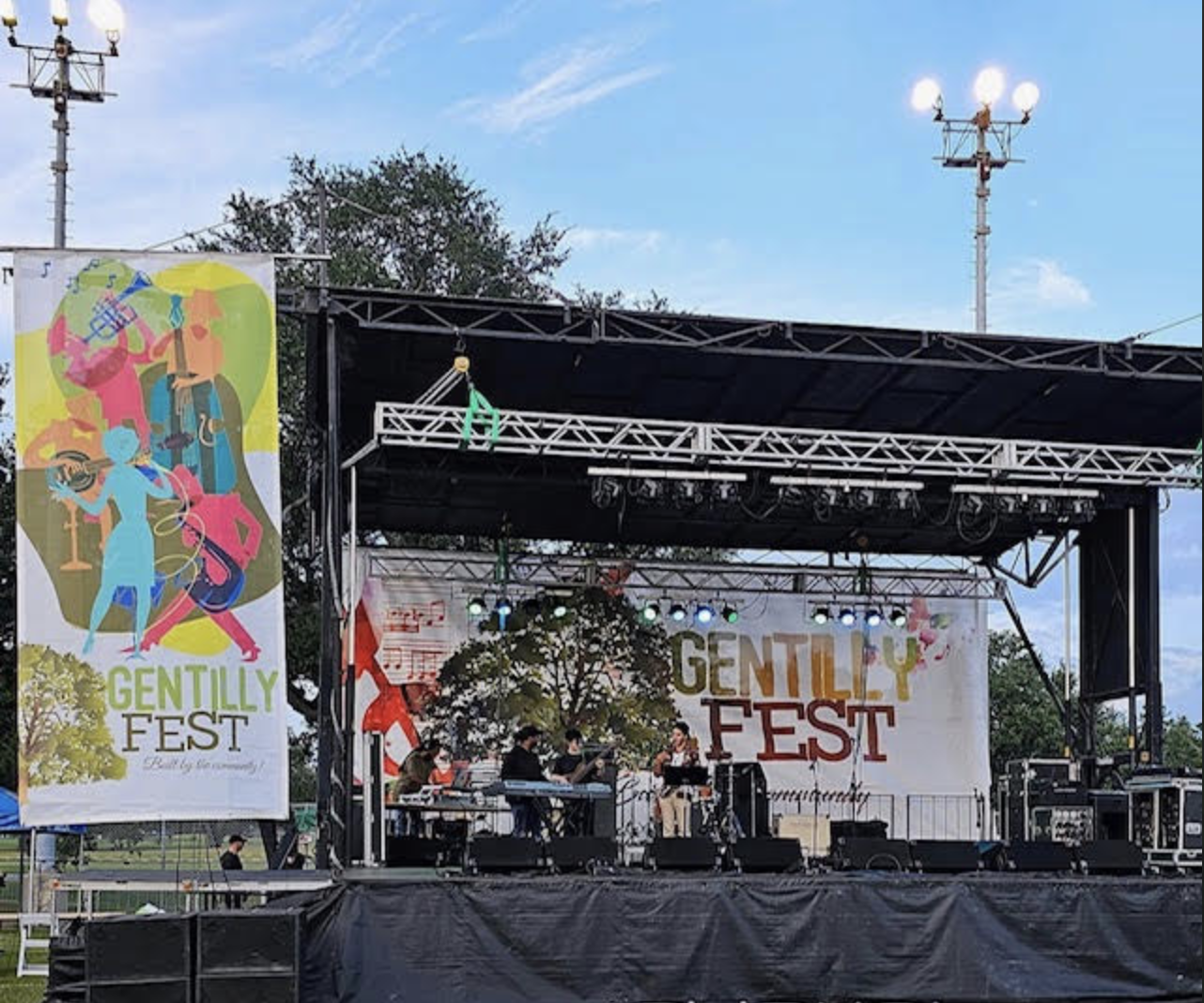 Outdoor music festival stage at Gentilly Fest with band performing under clear blue sky