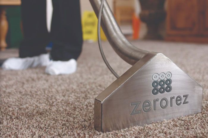 a person cleaning a carpet with a zerorez carpet cleaner