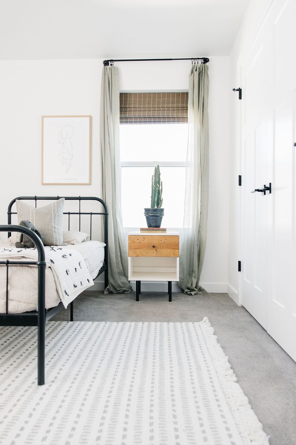 white and gray rug with fringe tassels lying on a gray carpet of a kids bedroom