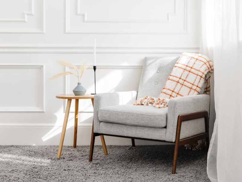 gray wool carpet with white and wood chair with small table