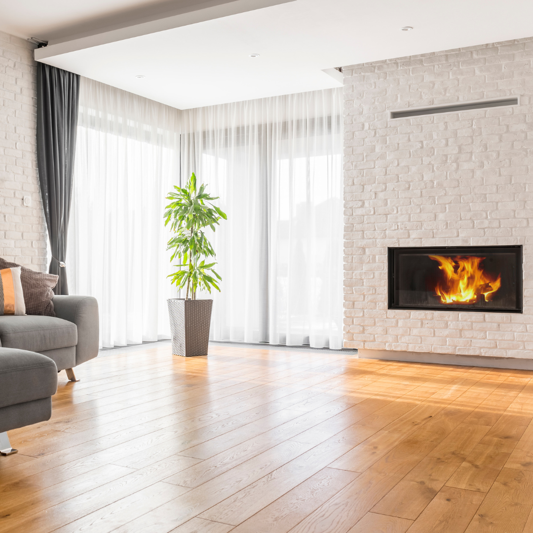 wood floor living room with plant and fireplace