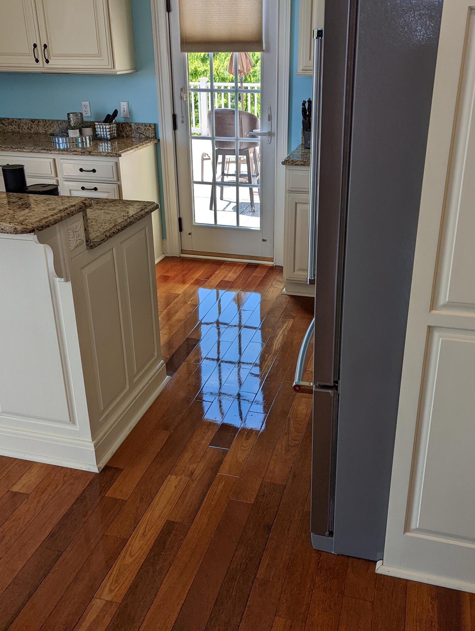 Shiny clean hardwood floor in a kitchen after its been cleaned, mopped, and sealed by a Zerorez Professional