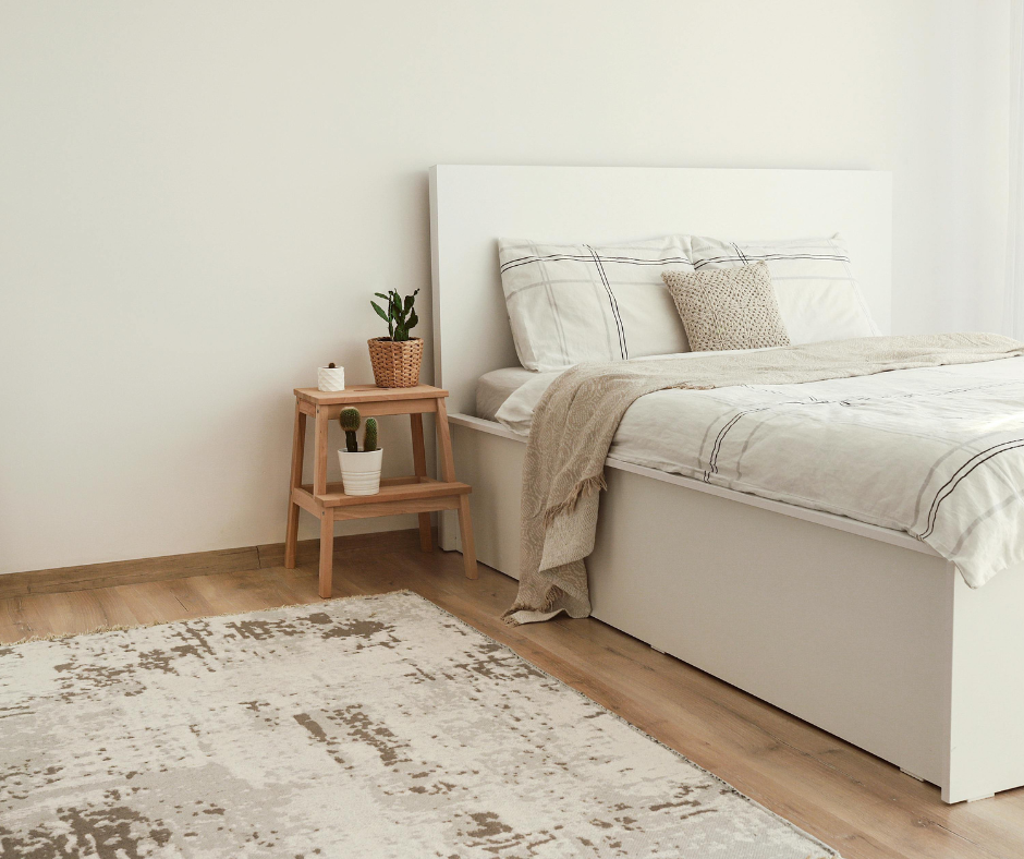 bedroom with white and cream bed and wood floors with rug