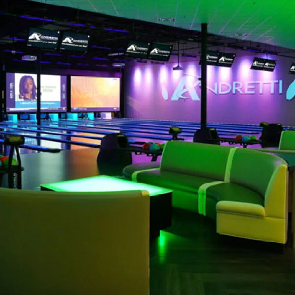 a room with green couches and a large screen