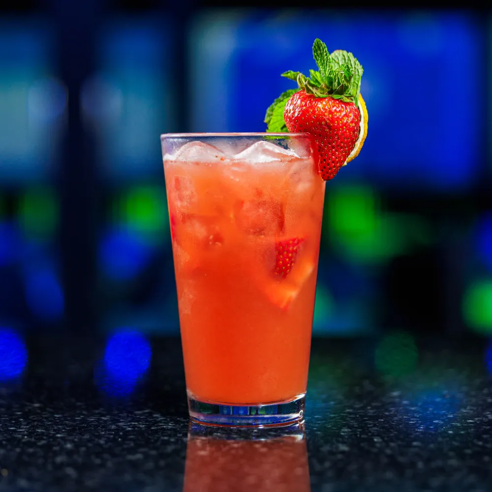 Spiked strawberry lemonade in a glass with a strawberry garnish