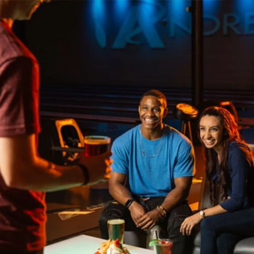a man and woman sitting at a table with drinks