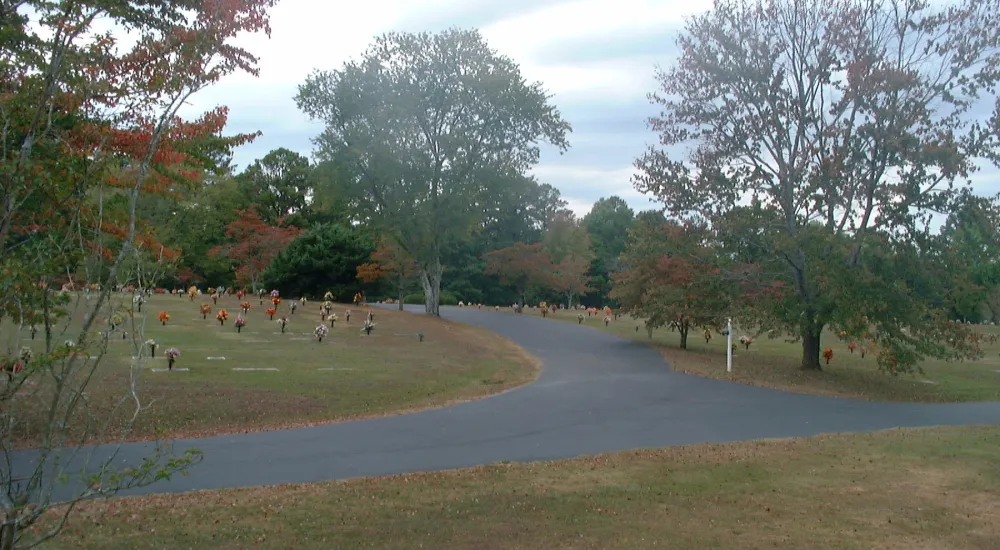 a group of people walking on a path through a park