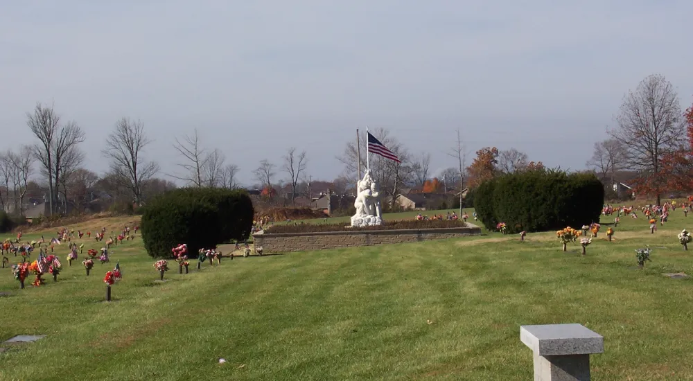 a large grassy field with a statue in the middle