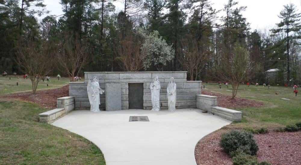 a stone structure with statues in a park
