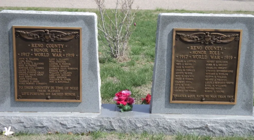 a gravestone with flowers and a tree