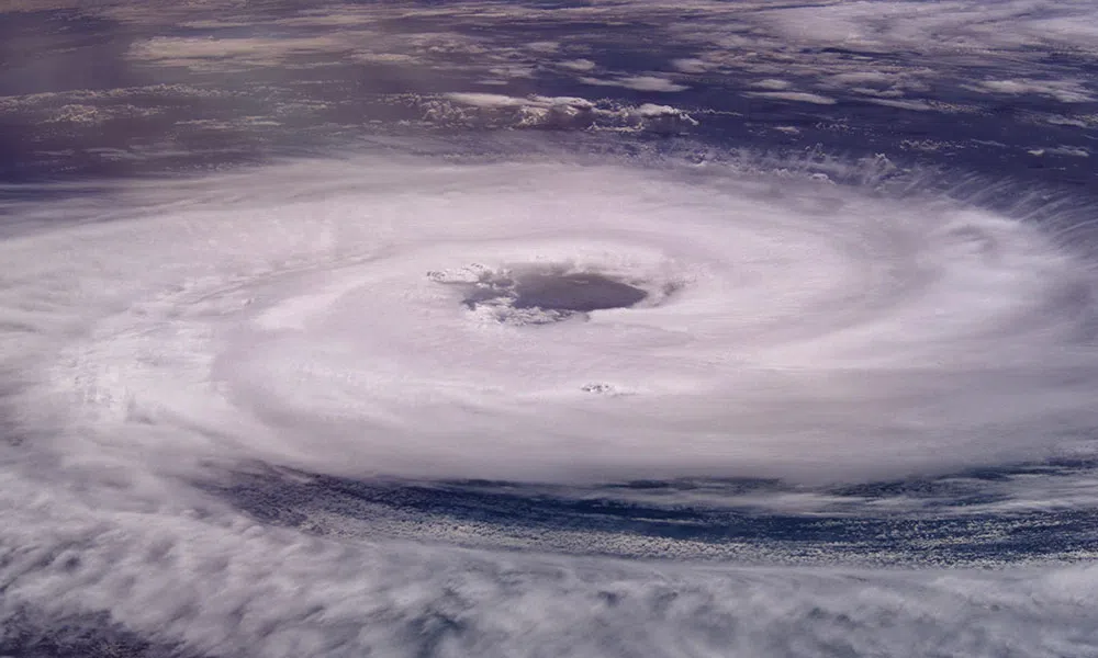 Satellite view of a hurricane with a distinct eye and swirling cloud bands over the ocean.
