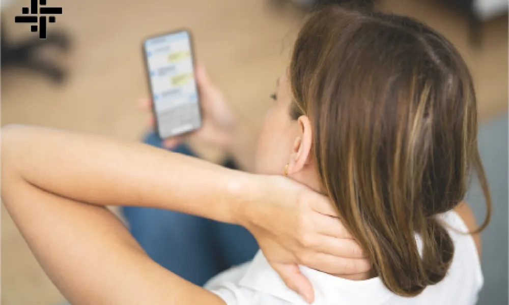 a woman holding a phone grabbing her neck