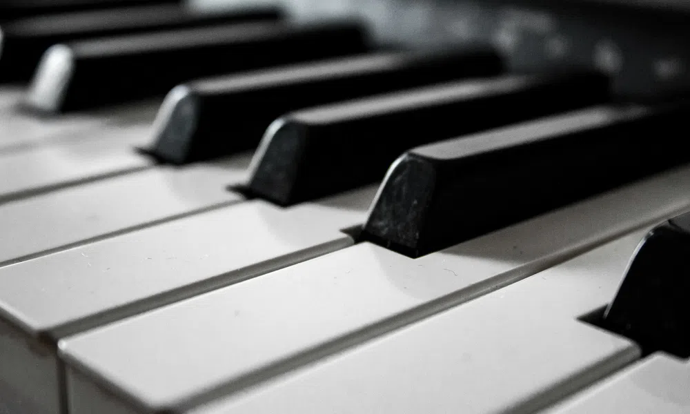 Close-up view of black and white piano keys arranged in repeating pattern on keyboard.