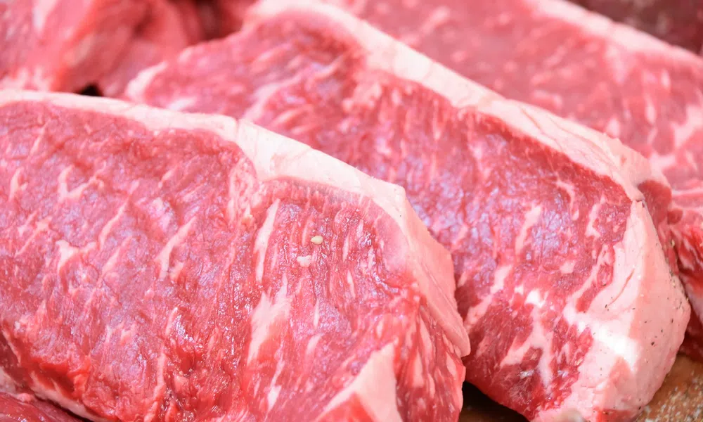 Close-up of fresh raw marbled beef steak slices with visible fat and muscle texture