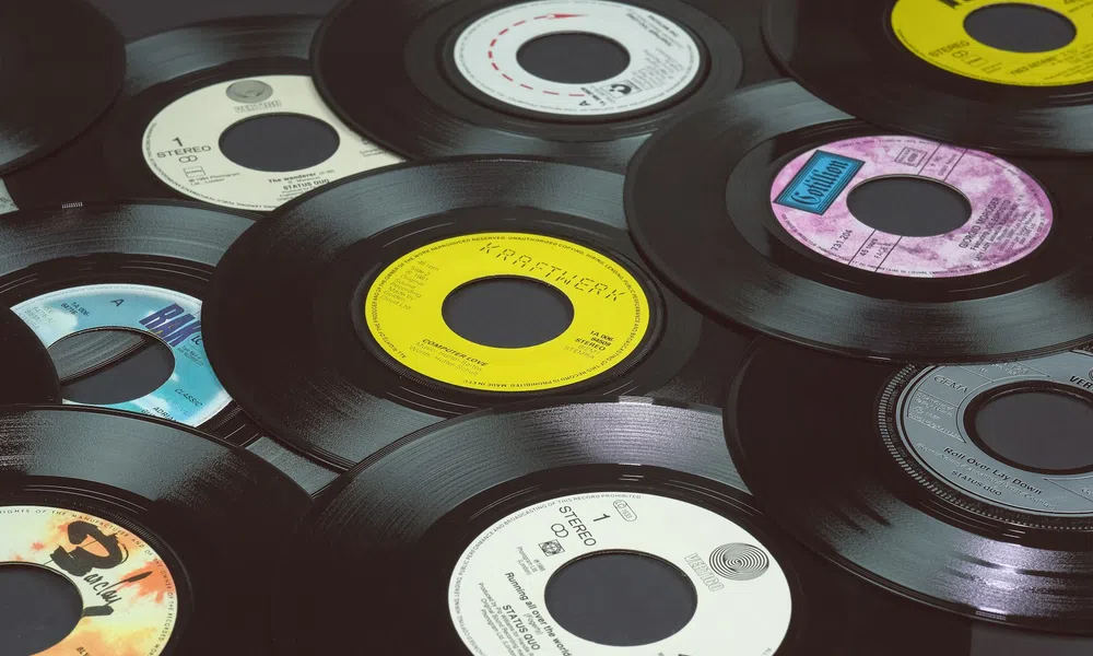 A collection of vintage 45 RPM vinyl records with colorful center labels overlapping on a flat surface.