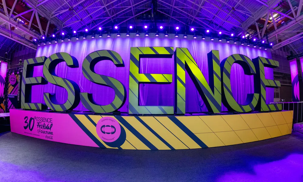Large colorful ESSENCE sign displayed at the 30th Essence Festival of Culture with vibrant purple lighting