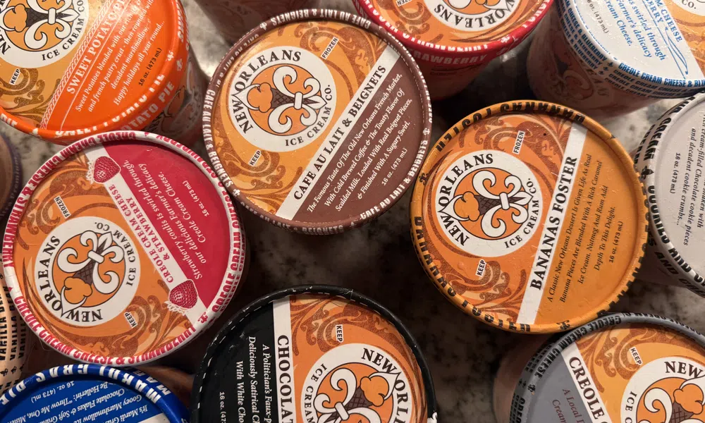 Top view of assorted New Orleans Ice Cream Company pints with various colorful flavors labeled on lids.