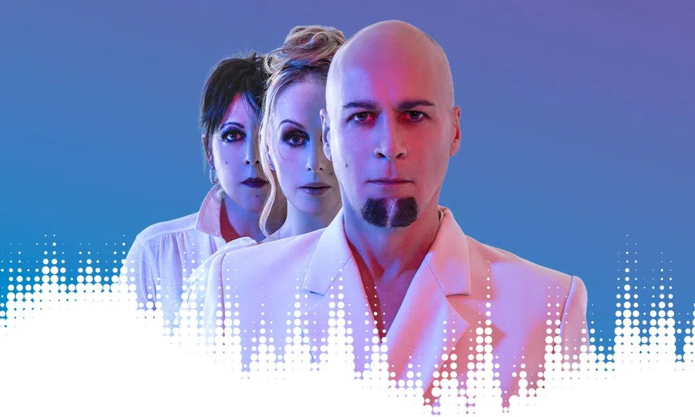 Three serious adults in white outfits with blue and pink lighting, arranged in a row against a blue background.