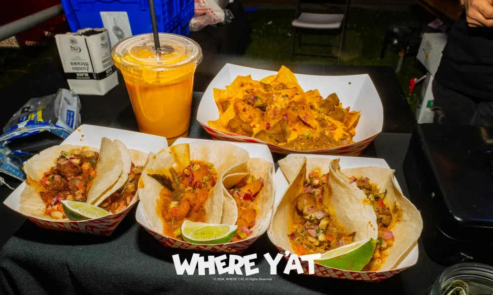 Delicious tacos and nachos served with a refreshing drink at a vibrant food stall.