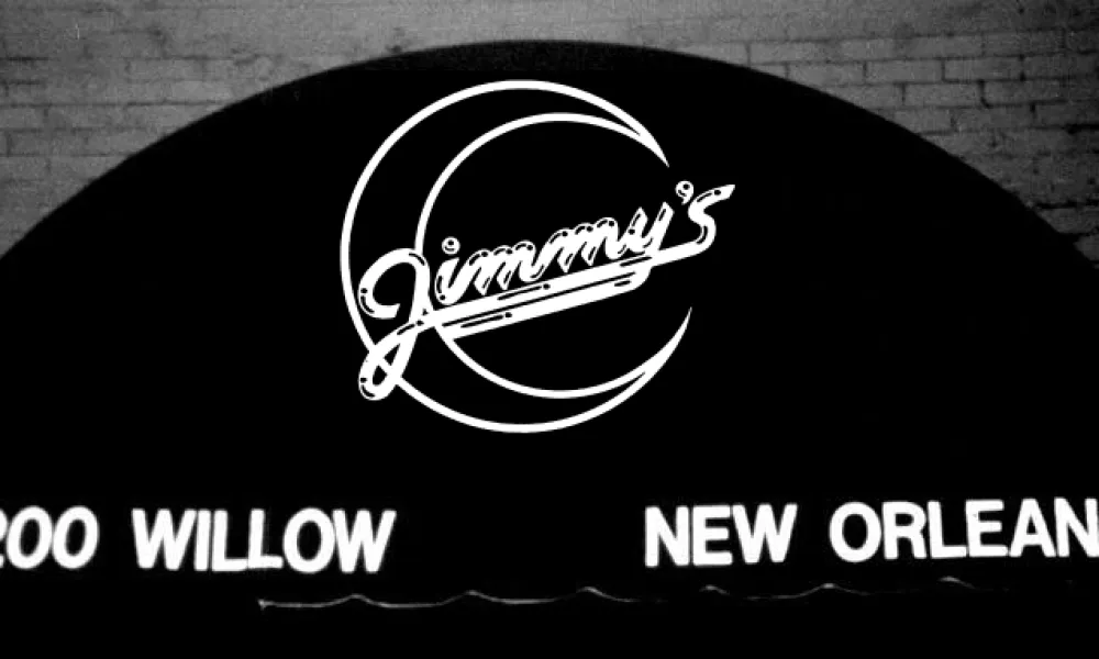 Black awning with white neon sign for Jimmy's at 8200 Willow in New Orleans on brick wall background