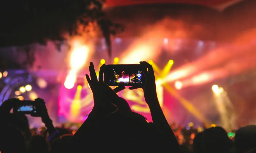 a person holding a camera in front of a crowd