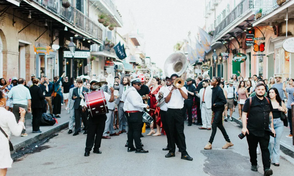 Street parade with a lively brass band playing music and a crowd of people enjoying the festive atmosphere.